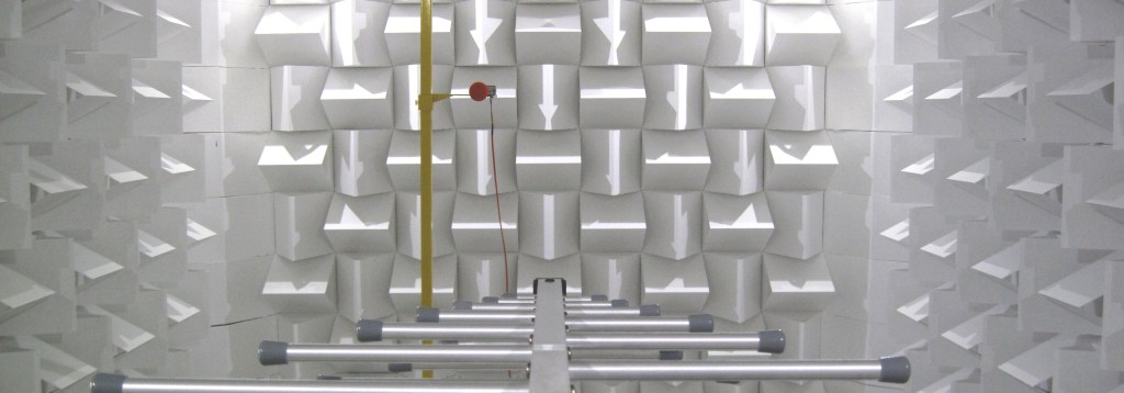 Photo shoing a field uniformity measurement in an anechoic EMC chamber. A log periodic antenna is being used as a transmit antenna and an isotropic field probe is used to measure the electric field strength.